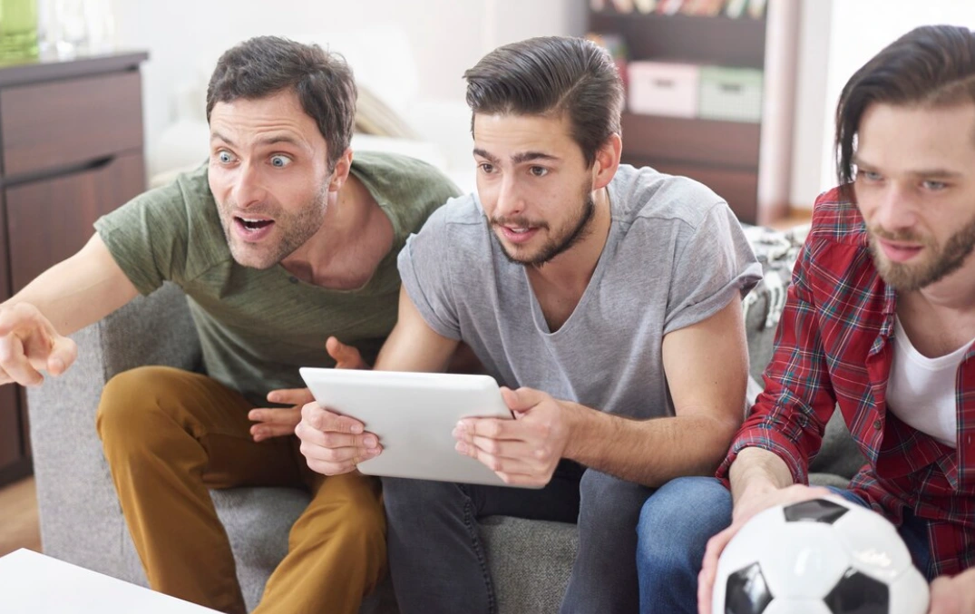 Three peoples watch fotball